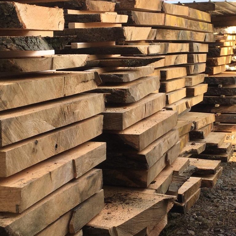 eingeschnittenes Eichenholz Gestapelte Holzbohlen in einem Lagerhaus mit warmem Licht.